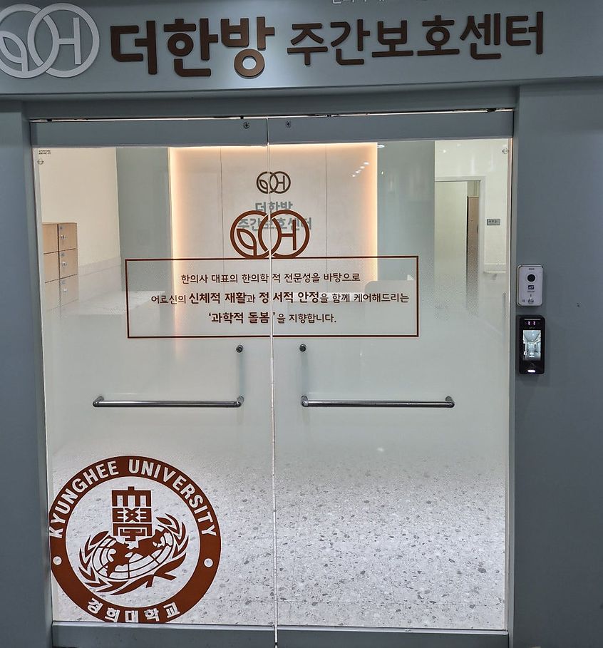 더한방 주간보호센터 유리 출입문과 경희대학교 로고